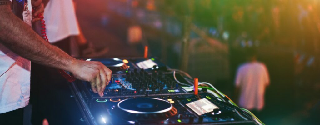 Dj mixing at beach night party during summer vacation outdoor - Focus on hand